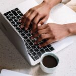 ノートパソコンで自分へのご褒美について考える50代女性